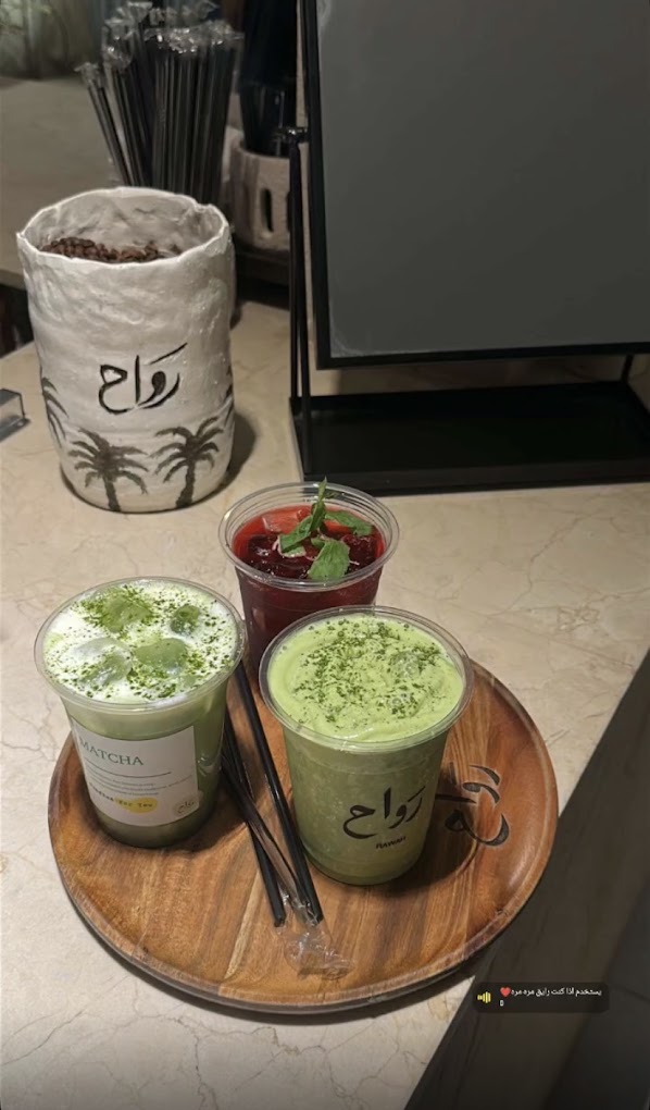 Two iced matcha lattes in rawah cups on a wooden tray