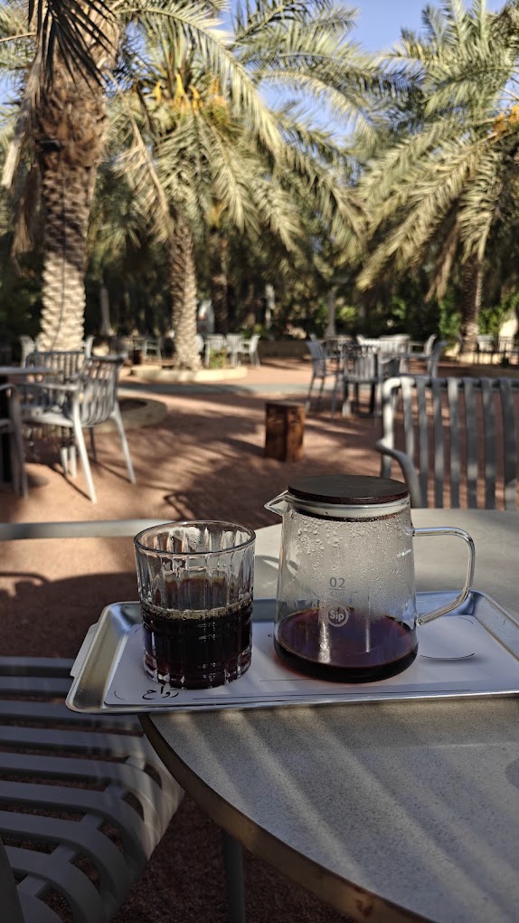 Hand-brewed V60 filter coffee served under the palms in the rawah garden